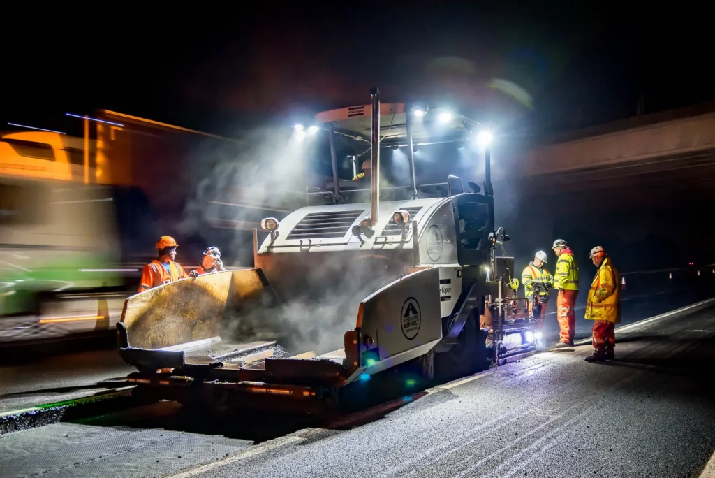Associated Asphalt Contracting Team Operating Heavy Machinery on Motorway